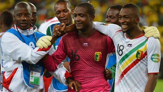 Mali's goalkeeper Soumbeyla Diakite (C) is congratulated by teammates after they beat South Africa on penalties