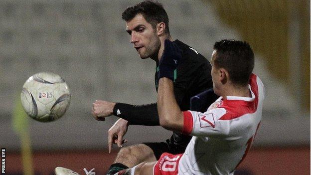 Northern Ireland defender Aaron Hughes competes against Malta's Andrew Cohen