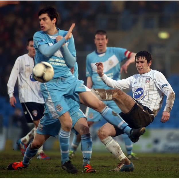 Ballymena United's Mark Surgenor attempts to block the clearance of Coleraine opponent Howard Beverland