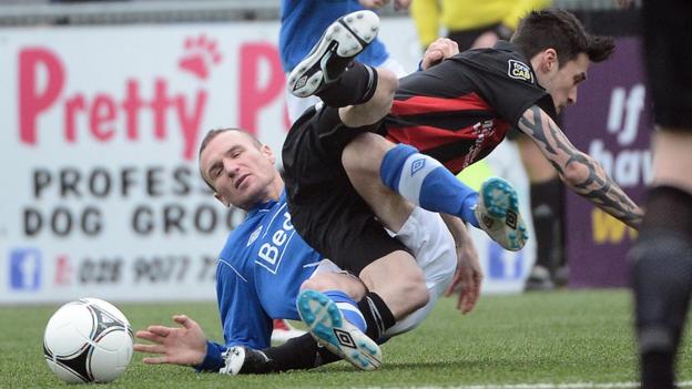 Glenavon's Andy Kilmartin and Declan Caddell of Crusaders hit the deck during the sixth round match at Seaview