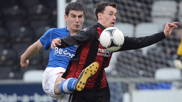 Glenavon defender Mark Haughey challenges Paul Heatley who scored a hat-trick for Crusaders in their 4-1 victory