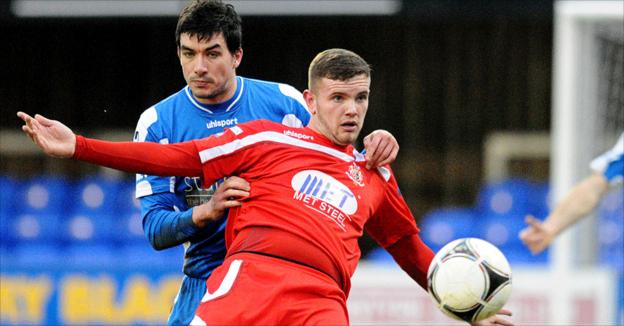 Dungannon defender Emmett Friars tries to halt the progress of Portadown forward Darren Murray