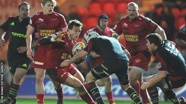 Andy Fenby of Scarlets takes on Munster's Duncan Williams