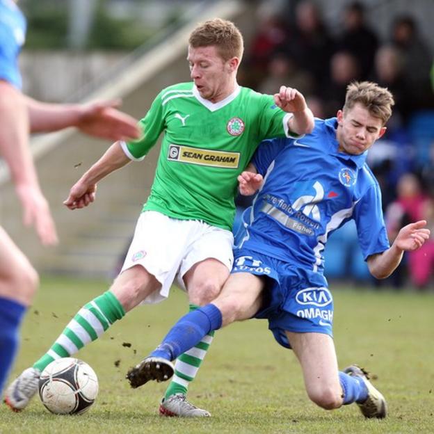 Stephen Garrett of Cliftonvillle is tackled by Gary Phair of Ballinamallard