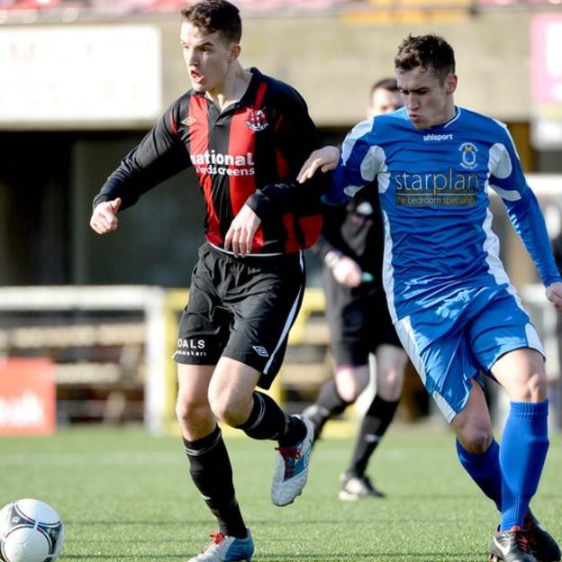 Josh Robinson of Crusaders on the ball against Dungannon Swifts opponent Johnny Topley