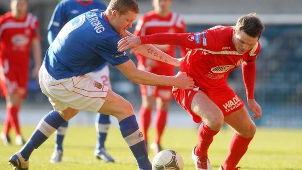 Linfield defender David Armstrong gets to grips with Portadown opponent Kevin Braniff at Windsor Park