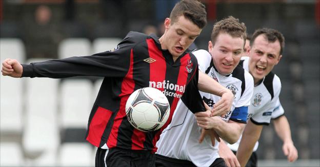 Joshua Robinson guards the ball from Ryan McCann and Michael Halliday during Crusaders' draw with Distillery
