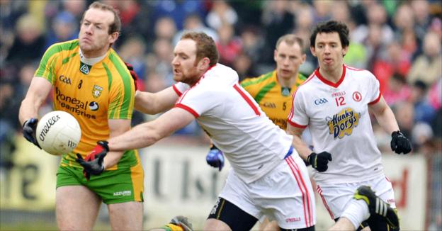 Neil Gallagher passes the ball for Donegal as Aidan Cassidy attempts to intervene for Tyrone at Healy Park