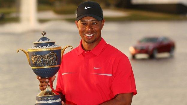 Tiger Woods poses with his trophy