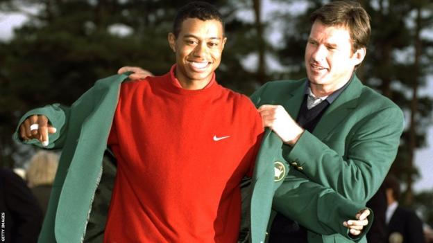 Tiger Woods is presented with his first Green Jacket by Nick Faldo