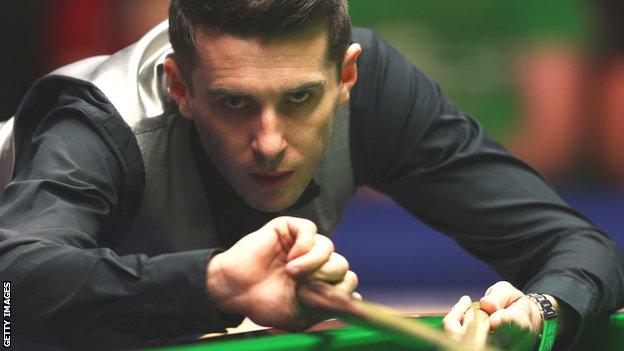 Mark Selby plays a shot with the rest during the Masters in January