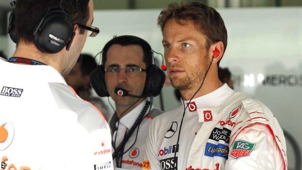 Jenson Button in discussion with his McLaren team
