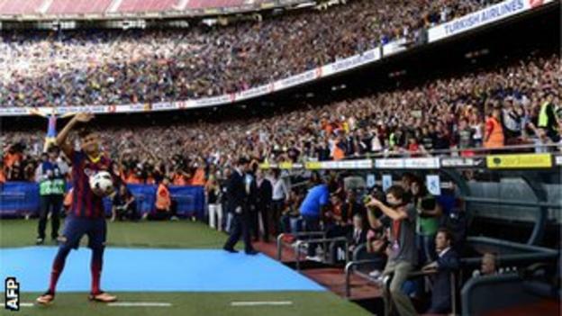 Neymar waves to the Barcelona supporters in the Nou Camp at his unveiling