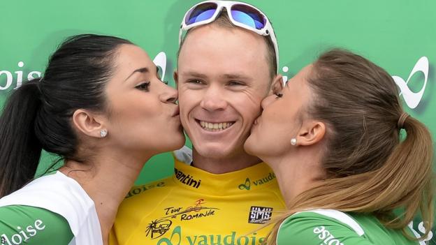 Chris Froome (centre) receives a traditional end-of-stage kiss from a couple of promotional girls