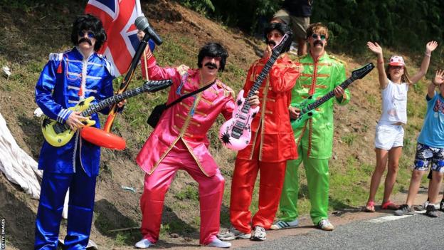 Fans dressed as The Beatles enjoy the atmosphere during stage fourteen