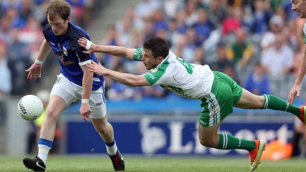 Martin Dunne of Cavan attempts to evade the diving challenge of London player David McGreevy at Croke Park