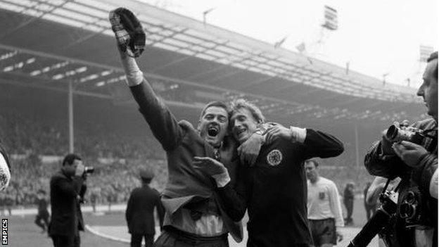 An ecstatic Scotland fan celebrates with Denis Law at the final whistle