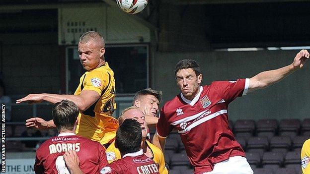 Newport County and Neorthampton battle for the ball in the air