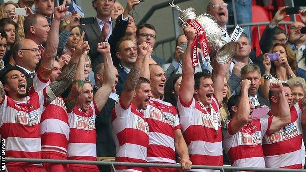Wigan's Sean O'Loughlin holds the Challenge Cup aloft