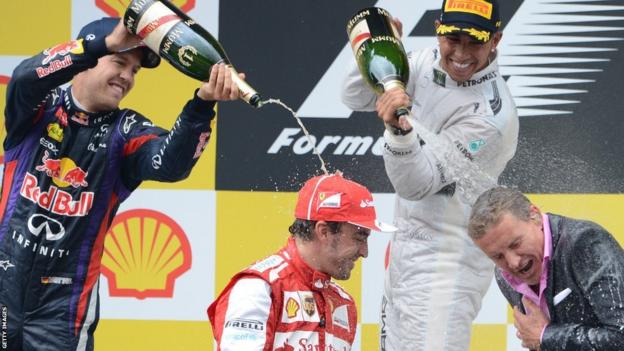 Sebastian Vettel (left) and Lewis Hamilton spray champagne on Ferrari's Spanish driver Fernando Alonso (second left) and David Coulthard on the podium