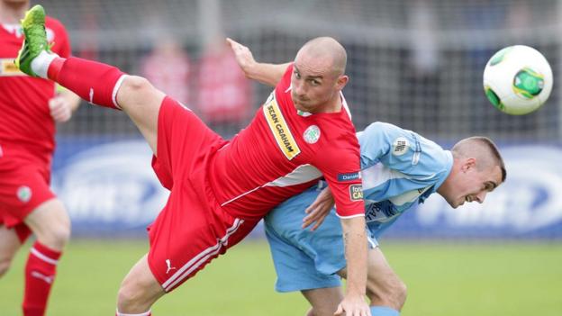 Barry Johnston of Cliftonville goes for the ball with Warrenpoint's Ruairi Devlin at Stangmore Park