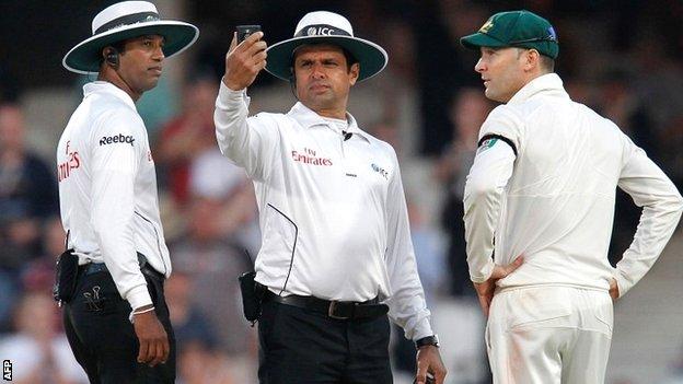 Umpires Aleem Dar and Kumar Dharmasena assess the light meter
