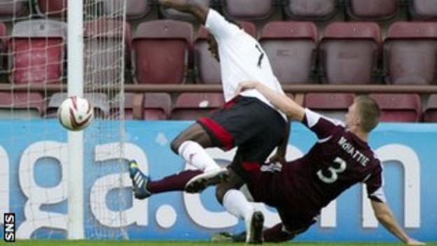 Kevin McHattie slides in to tackle Calvin Zola during the match at Tynecastle