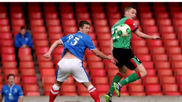 Mark McAllister and Calum Birney take to the air during Saturday's Belfast derby at Windsor Park