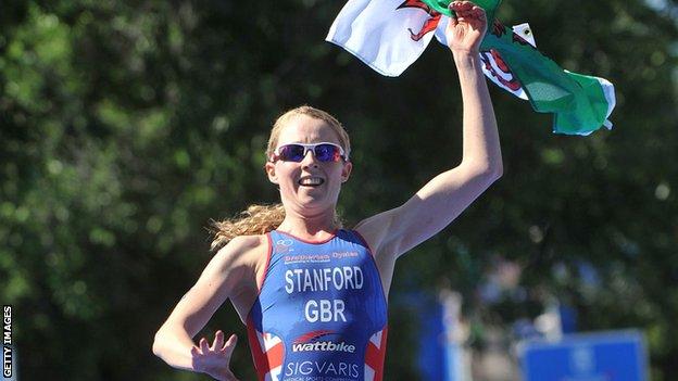 Non Stanford waves a Welsh flag as she crosses the line to win the ITU world series triathlon in Madrid in 2013