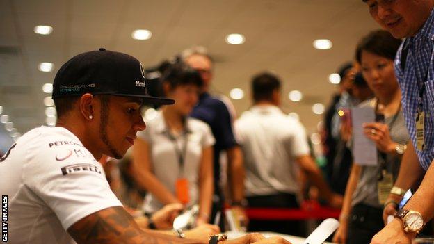 Lewis Hamilton signs autographs for fans in Singapore