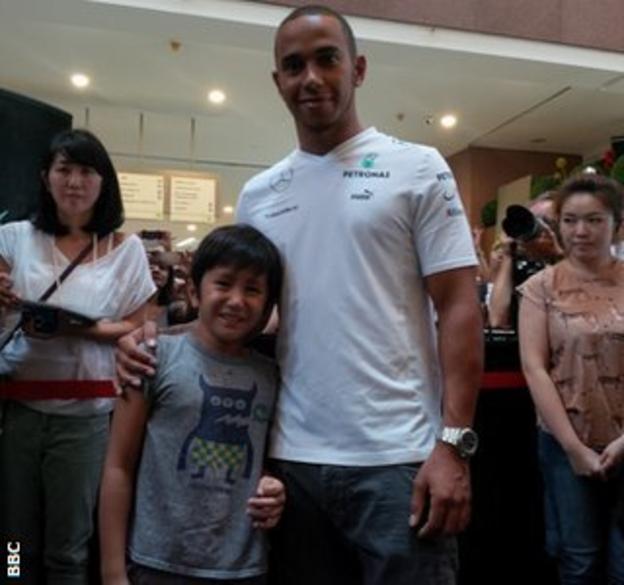 Lewis Hamilton poses with a fan