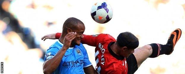 Vincent Kompany battles for the ball with Manchester United striker Wayne Rooney