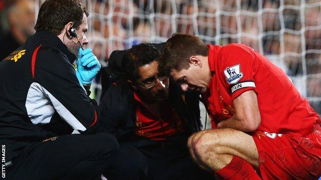 Steven Gerrard receives treatment from Zaf Iqbal on the pitch at Stamford Bridge
