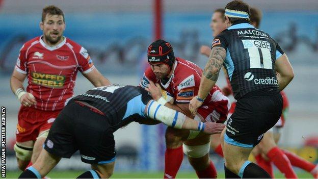 George Earle of the Scarlets runs into a Glasgow tackler