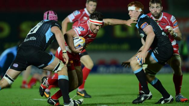 Scarlets hooker Emyr Phillips runs into Glasgow defenders Tim Swinson and Rob Harley during the Pro12 match at Parc y Scarlets that ended in a 17-12 win for Glasgow
