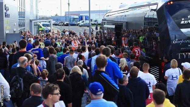 Football fans watch as the Newcastle United team arrive prior to the Barclays Premier League match between Cardiff City and Newcastle United at Cardiff City Stadium