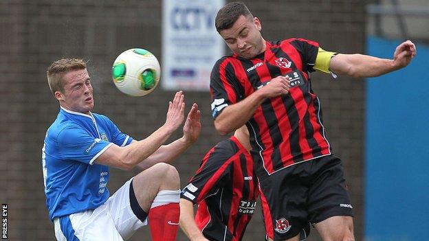 Linfield's Aaron Burns competes against Crusaders skipper Colin Coates in last month's Premiership clash