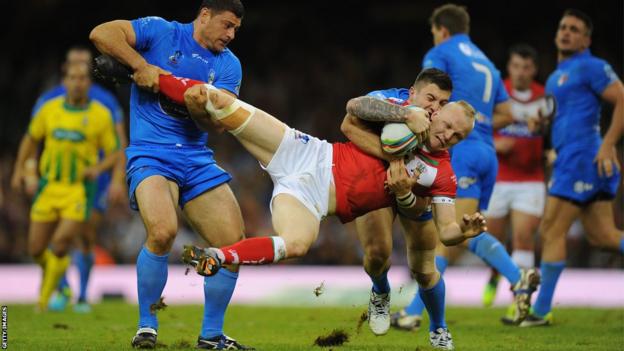 Italy players Mark Minichello (l) and Joshua Mantellato (r) combine to halt Rhys Evans as Wales trail 14-12 at half-time
