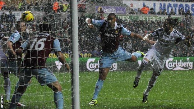Swansea City's Chico Flores (right) heads an attempt on goal watched by West Ham United's Winston Reid (centre)