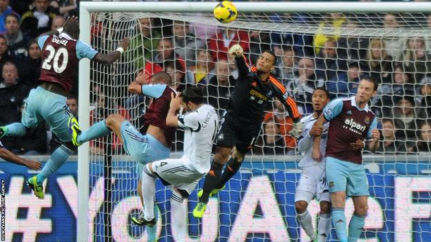 Swansea City goalkeeper Michel Vorm punches clear under pressure from West Ham United players in their Premier League game at the Liberty Stadium