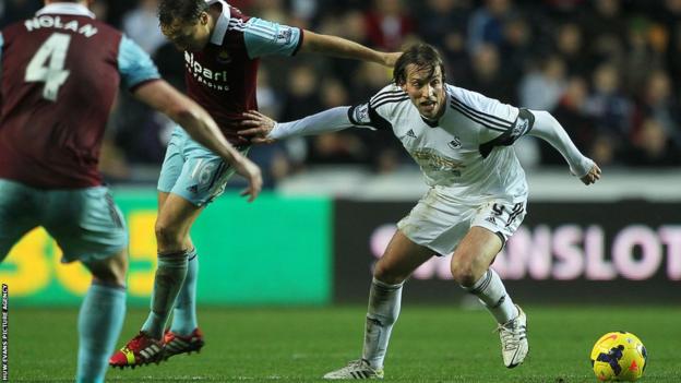 Michu of Swansea City gets away from Mark Noble of West Ham United but neither side can find a breakthrough and the game ends 0-0