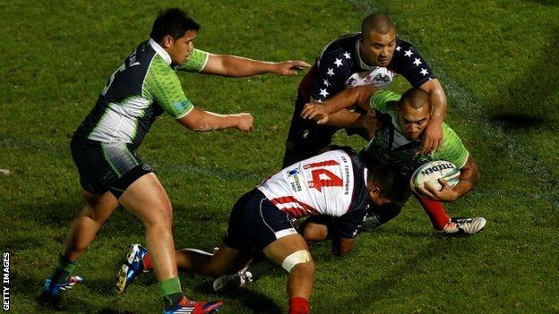 Zeb Taia of the Cook Islands tries to get through the USA defence