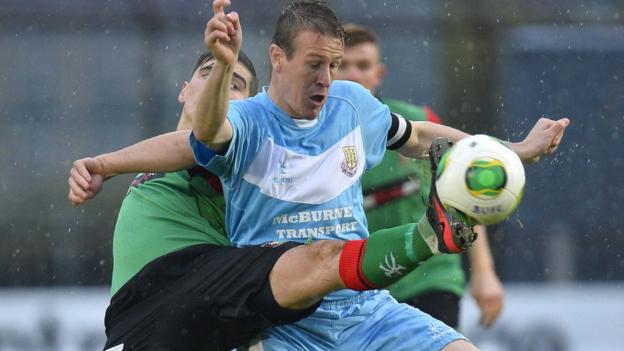 Glentoran's Jimmy Callacher stretches in an attempt to take the ball away from Ballymena United skipper Allan Jenkins