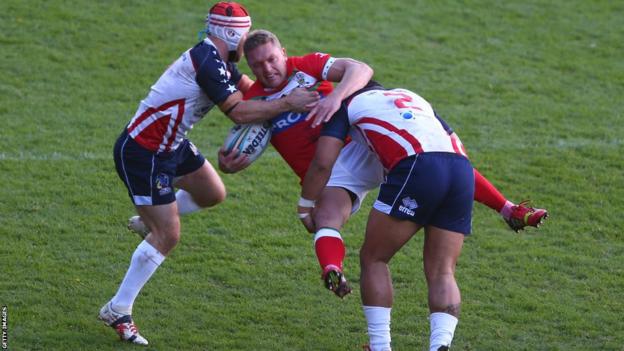 Christiaan Roets is upended by USA tacklers Craig Priestly and Bureta Faraimo during the Rugby League World Cup Group D game in Wrexham but later puts Wales ahead with the first try
