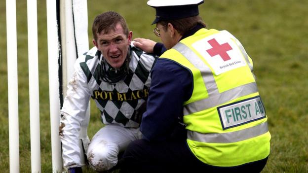 Jockey AP McCoy is attended to by a medic after a fall