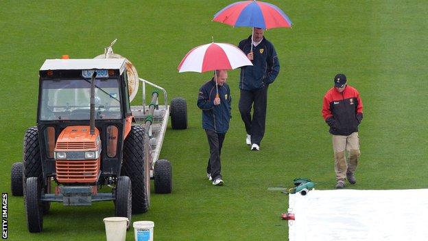Umpires inspect the outfield