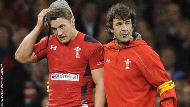 Jonathan Davies is helped off the pitch by Wales physio Mark Davies