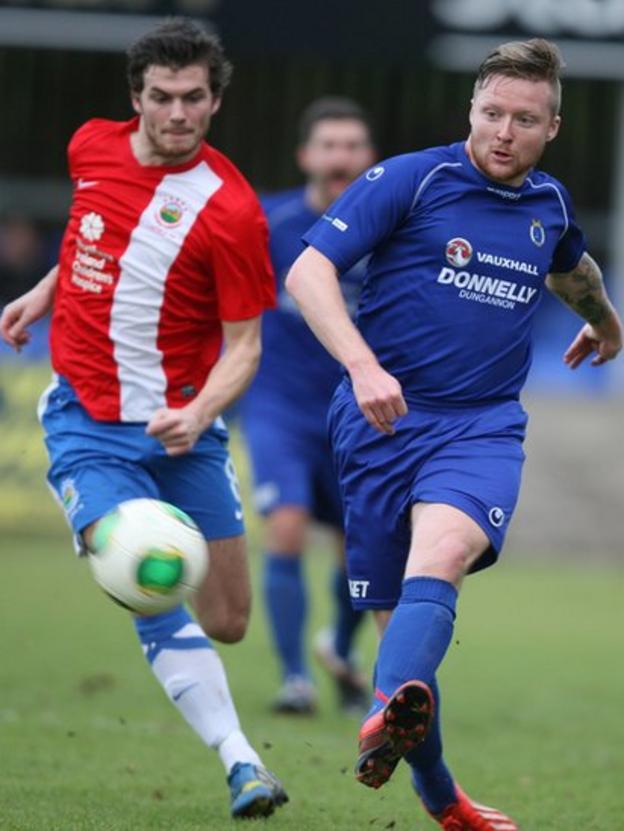 Matt Hazley gets to the ball ahead of Linfield opponent Philip Lowry during the match at Stangmore Park which Dungannon Swifts won 1-0