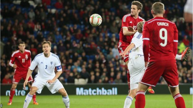 Andy King gets above his marker to give Wales the lead against Finland