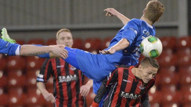 Cathal Beacom of Ballinamallard United competes for the ball against Crusaders opponent Matthew Snoddy